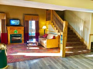 a living room with a staircase with a couch and a television at Quality Inn Greenville North in Greenville