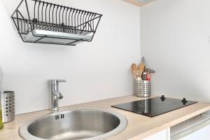 um balcão de cozinha com um lavatório e uma cesta na parede em View on the Bastille Center Terrace All equipped #E0 em Grenoble
