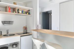 uma cozinha com um lavatório e um balcão com uma cadeira em View on the Bastille Center Terrace All equipped #E0 em Grenoble