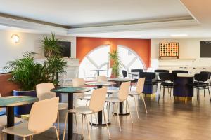 une salle à manger avec des tables, des chaises et des plantes dans l'établissement Aparthotel Adagio Monaco Palais Joséphine, à Beausoleil