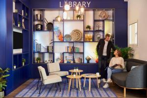 a man and woman standing in a living room at Aparthotel Adagio Monaco Palais Joséphine in Beausoleil