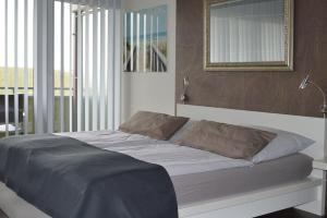 a bedroom with a bed with a mirror and a window at Encore-ONE in Büsum