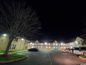 a parking lot in front of a building at night at Travel Inn Motel in Hartford
