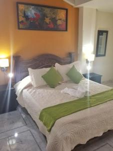 a bedroom with a bed with green and white pillows at Sam'S VIP Hostel San Gil in San Gil