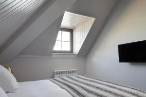 a attic bedroom with a bed and a tv at Pujolo by FeelFree Rentals in Naut Aran