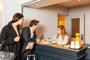 a group of people standing around a reception desk at Aparthotel Adagio Access La Défense - Léonard De Vinci in Courbevoie