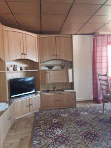 a living room with wooden cabinets and a flat screen tv at Ferienwohnung-Lalka in Altenkirchen