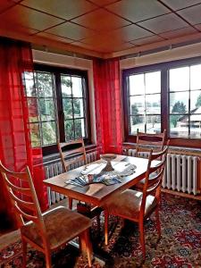 a dining room with a table and chairs and windows at Ferienwohnung-Lalka in Altenkirchen
