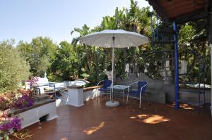 a patio with a table and an umbrella at Villa Eva in Anacapri