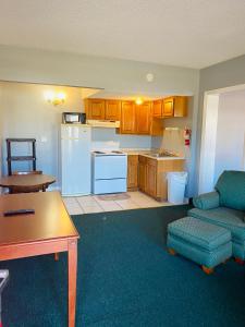 a kitchen with a couch and a table in a room at Traveler's Place Inn & Suites in Scottsboro