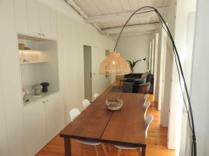 a dining room with a wooden table and a light fixture at Oporto Delight 2 Luxury Apartment in Historic Center Max 4p in Porto