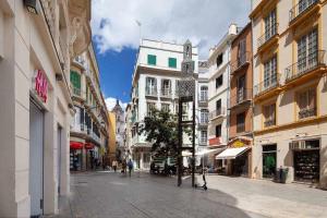 una calle de la ciudad con edificios y gente caminando por la calle en Wanderlust Malaga Apartamentos 2, en Málaga