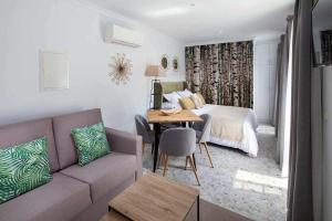 sala de estar con sofá y cama en Wanderlust Malaga Apartamentos Atico, en Málaga