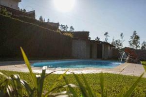 a swimming pool in a yard next to a fence at Casa Rural do Salgueirinho in Santo Tirso