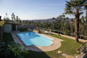 a swimming pool in the yard of a house at Casa Rural do Salgueirinho in Santo Tirso