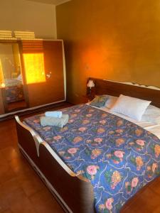 a bedroom with a large bed with a floral blanket at Friuli Appartamenti in Cormòns