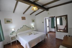 a bedroom with a white bed and a mirror at Villa Eva in Anacapri