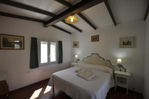 a bedroom with a white bed and a window at Villa Eva in Anacapri