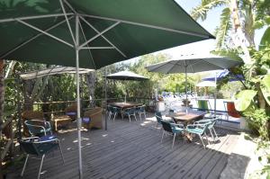 a wooden deck with tables and chairs and umbrellas at Villa Eva in Anacapri