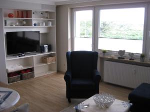 ヴェスターラントにあるHaus-Quisisana-App-6のリビングルーム(椅子、テレビ付)