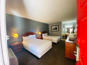 a hotel room with two beds and a bathroom at Traveler's Place Inn & Suites in Scottsboro
