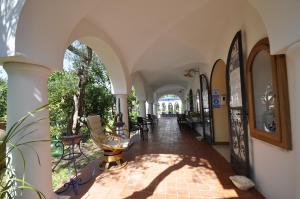 an arcade of a building with tables and chairs at Villa Eva in Anacapri