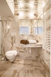 a white bathroom with a toilet and a sink at Jacuzzi Opera Suite in Budapest