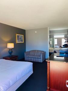 Traveler's Place Inn & Suites في سكوتسبورو: غرفه فندقيه بسرير واريكه