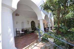 a porch of a white building with trees and plants at Villa Eva in Anacapri