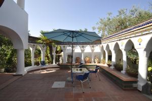 a patio with a table and chairs and an umbrella at Villa Eva in Anacapri