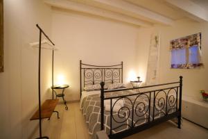ein Schlafzimmer mit einem schwarzen Bett in einem Zimmer in der Unterkunft Historic Modica in Modica