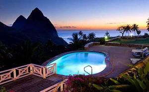 
a beach with a pool and a balcony overlooking the ocean at La Haut Resort in Soufrière
