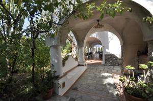 an arched entry way to a building with trees at Villa Eva in Anacapri