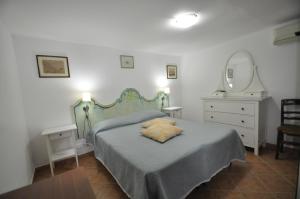 a bedroom with a bed with a mirror and a dresser at Villa Eva in Anacapri