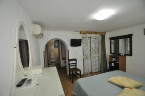 a bedroom with a bed and a desk and a mirror at Villa Eva in Anacapri
