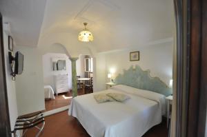 a bedroom with a white bed with a blue headboard at Villa Eva in Anacapri