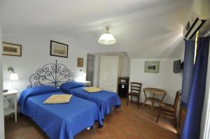 a bedroom with three beds and a table and chairs at Villa Eva in Anacapri