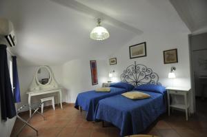 a bedroom with two blue beds and a mirror at Villa Eva in Anacapri