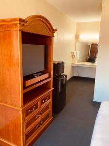 a hotel room with a large entertainment center with a television at Traveler's Place Inn & Suites in Scottsboro