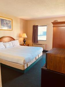 a hotel room with a bed and a window at Traveler's Place Inn & Suites in Scottsboro