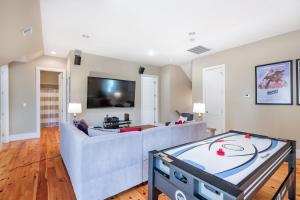 a living room with a couch and a flat screen tv at 114 W Huron - Sand Castle - Saltwater Pool - Heated upon request in Folly Beach
