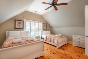 two beds in a bedroom with a ceiling fan at 114 W Huron - Sand Castle - Saltwater Pool - Heated upon request in Folly Beach +33 photos