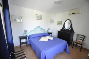 a bedroom with a blue bed and a mirror at Villa Eva in Anacapri