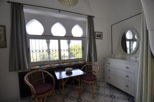 a room with a table and two chairs and a window at Villa Eva in Anacapri