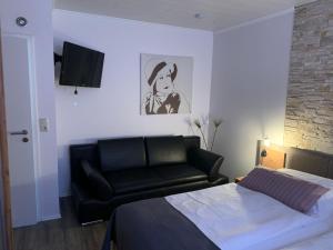 a bedroom with a bed and a black leather couch at Haus-Encore-Wohnung-3 in Büsum