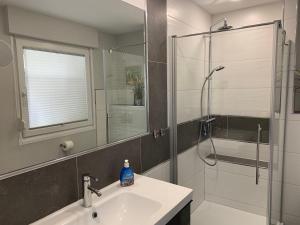 a bathroom with a sink and a shower with a glass door at Haus-Encore-Wohnung-3 in Büsum