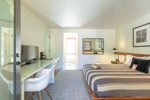 Habitación de hotel con cama y TV en Little Beaver Inn en Green Mountain Falls