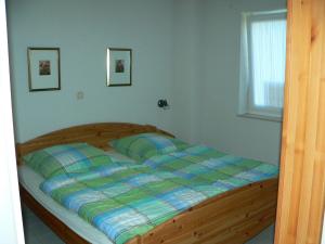 a bedroom with a bed with a wooden bed frame at WBHS53001-Die-Ostsee-so-nah in Westerbergen