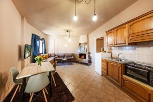 a kitchen with a table and a living room at White Apartments by White Hills in Arachova