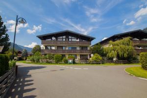 ein großes Gebäude mit einer Einfahrt davor in der Unterkunft Apartment Schmid - Steinbock Lodges in Maishofen